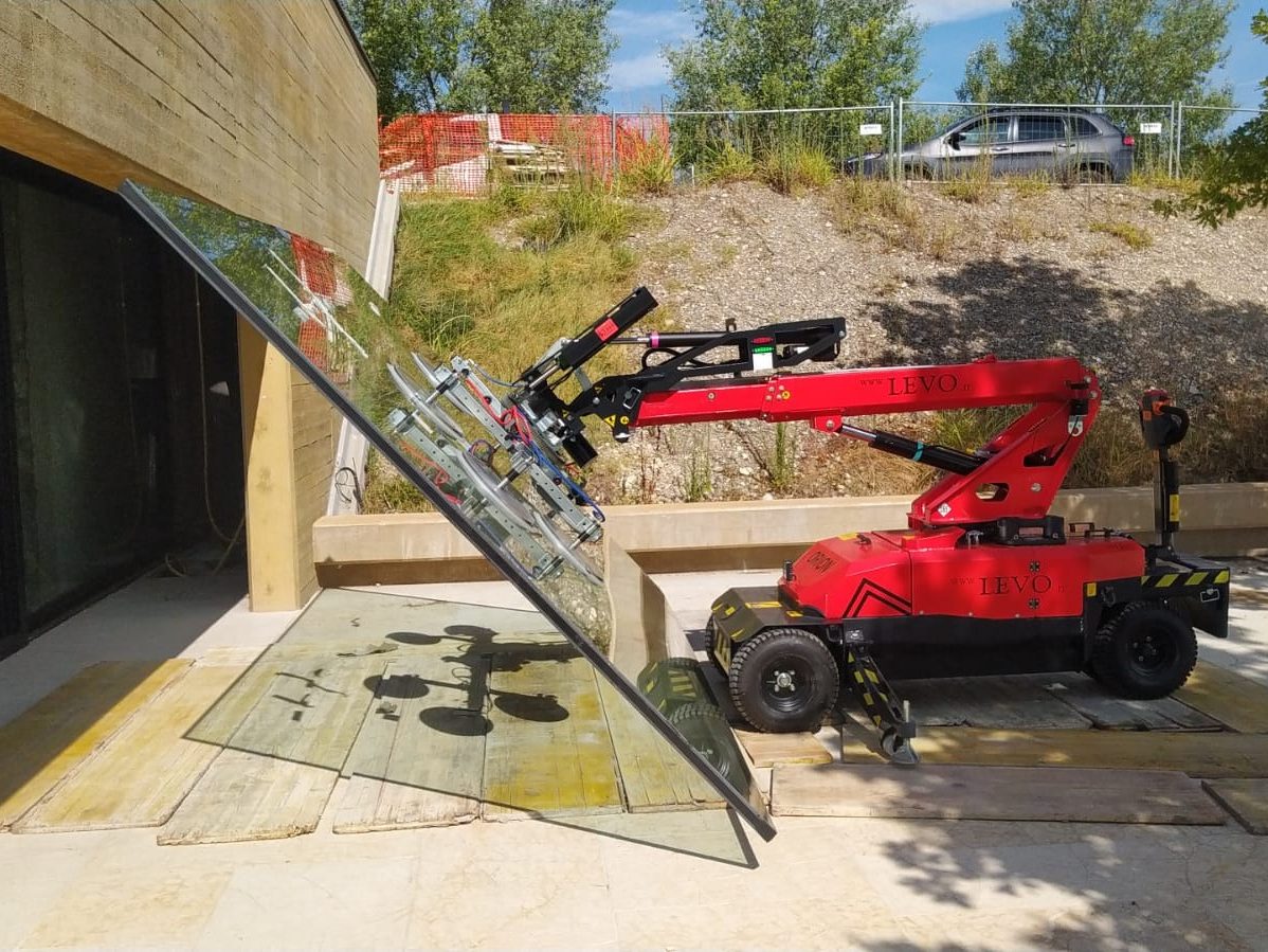 Robot ORION con testata a ventose durante la posa di una vetrata a filo terra
